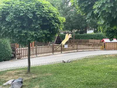 a wooden fence with a slide in a playground at MONFas APARTMENT PROVENCE IN PRAGUE in Prague