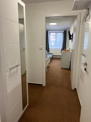a hallway with a room with a bed and a door at Pension Hájek in Prague