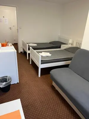 a room with three beds and a couch at Pension Hájek in Prague
