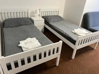 two beds in a room with towels on them at Pension Hájek in Prague