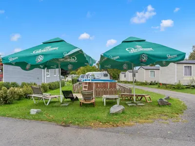 two green umbrellas and a table and chairs in the grass at Holiday Home Prima by Interhome in Prague