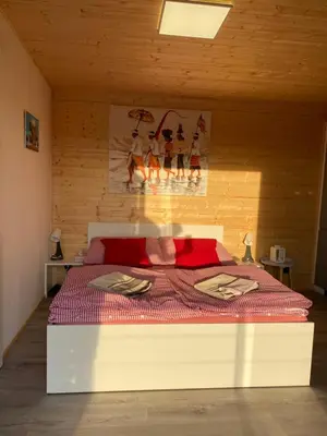 a bedroom with a bed with a red comforter at Chatka - B - Vyhlídka nad řekou in Zdiby