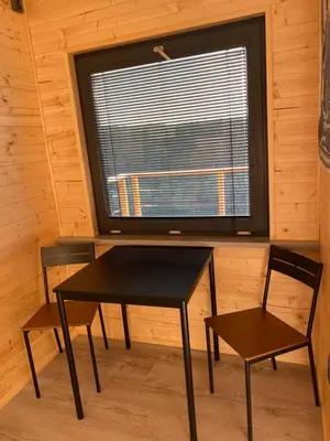 a room with a table and two chairs and a window at Chatka - B - Vyhlídka nad řekou in Zdiby