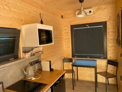 a kitchen with a stove and a counter with a table at Chatka - B - Vyhlídka nad řekou in Zdiby