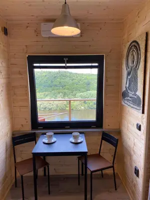 a table and chairs in a room with a window at Chatka - B - Vyhlídka nad řekou in Zdiby