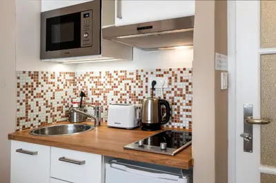 a living room with a couch and a kitchen at Studio Apartment - Tower Petrin in Prague