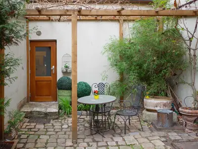 a patio with a table and chairs in front of a house at Romantic nest under Prague Castle in Prague