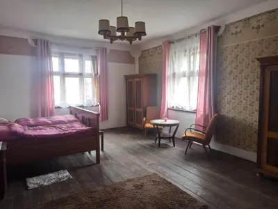 a bedroom with a bed and a table and windows at Apartmán Měňany in Měňany