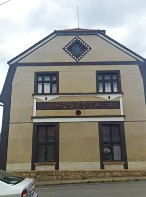 a building with a sign on the side of it at Apartmán Měňany in Měňany