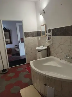 a bathroom with a tub and a sink and a mirror at Apartmán Měňany in Měňany