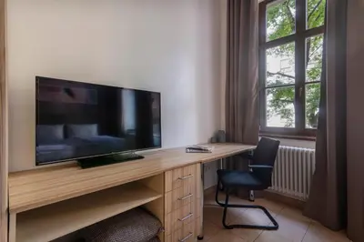 a room with a desk with a television and a chair at Bohemian Dreams Apartments and Suites by Dwellfort in Prague