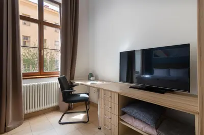 a room with a desk with a television and a chair at Bohemian Dreams Apartments and Suites by Dwellfort in Prague