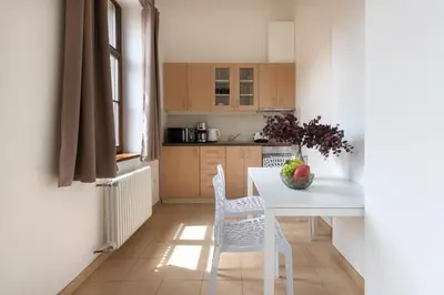 a kitchen with a white table and two chairs at Bohemian Dreams Apartments and Suites by Dwellfort in Prague