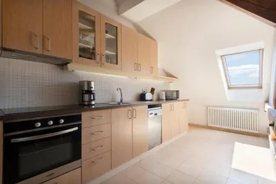 a kitchen with wooden cabinets and a stove top oven at Bohemian Dreams Apartments and Suites by Dwellfort in Prague