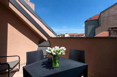 a vase of flowers on a table on a balcony at Bohemian Dreams Apartments and Suites by Dwellfort in Prague