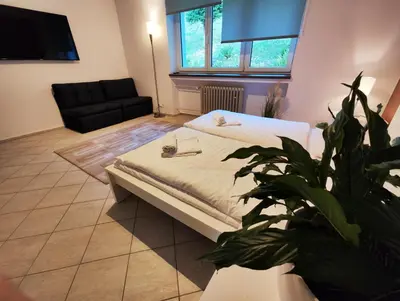 a bedroom with a bed and a black couch at Vila Prag in Prague
