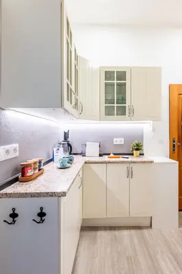 a kitchen with white cabinets and a counter top at Prague Days - Stylish Condo with Netflix in Hip Karlín in Prague