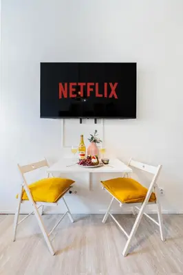 a white table with two chairs and a netflix sign at Prague Days - Stylish Condo with Netflix in Hip Karlín in Prague