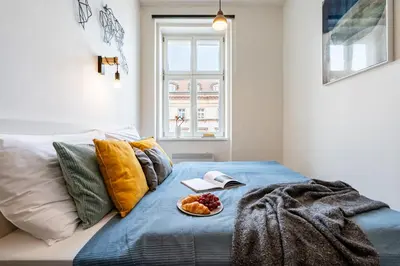 a bed with a plate of fruit on it at Prague Days - Stylish Condo with Netflix in Hip Karlín in Prague