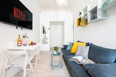 a living room with a blue couch and a table at Prague Days - Stylish Condo with Netflix in Hip Karlín in Prague