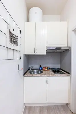 a kitchen with white cabinets and a sink at Prague Days - Stylish Condo with Netflix in Hip Karlín in Prague
