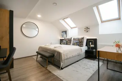 a bedroom with a bed with a mirror and a table at CORU House in Prague