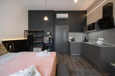 a small bedroom with a bed and a kitchen at CORU House in Prague
