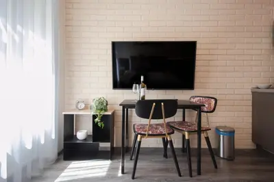 a dining room with a table and two chairs and a tv at CORU House in Prague