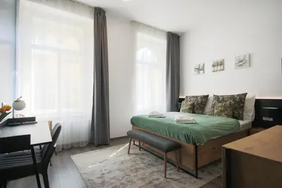 a bedroom with a bed and a table and a desk at CORU House in Prague