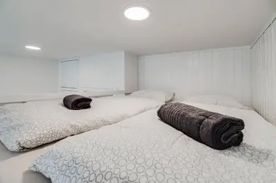 two twin beds in a room with white walls at Studio Mala Strana - Prague historical center in Prague