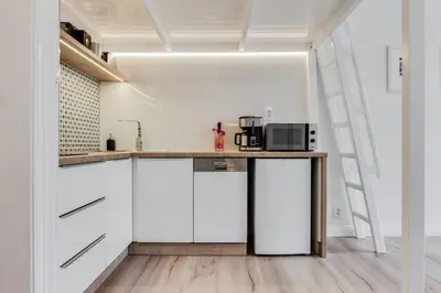a kitchen with white cabinets and a counter with a microwave at Studio Mala Strana - Prague historical center in Prague