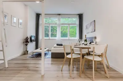 a white living room with a table and chairs at Studio Mala Strana - Prague historical center in Prague