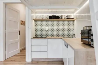 a kitchen with white cabinets and a white door at Studio Mala Strana - Prague historical center in Prague