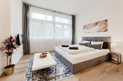 a bedroom with a large bed and a table at Studio Mala Strana - Prague historical center in Prague