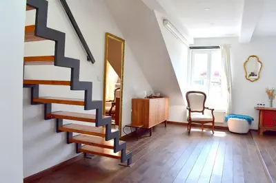 a staircase in a room with a chair and a mirror at Lux Duplex rooftop loft with an amazing terrace & home cinema in Prague
