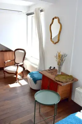 a living room with a table and chairs and a mirror at Lux Duplex rooftop loft with an amazing terrace & home cinema in Prague