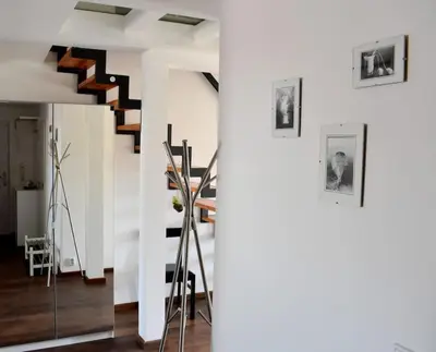 a living room with a staircase and a mirror at Lux Duplex rooftop loft with an amazing terrace & home cinema in Prague