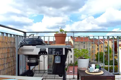 a grill sitting on top of a balcony at Lux Duplex rooftop loft with an amazing terrace & home cinema in Prague