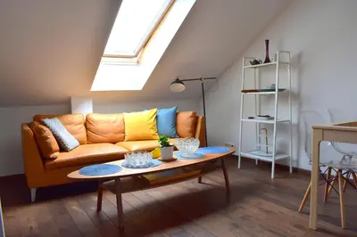 a living room with a couch and a table at Lux Duplex rooftop loft with an amazing terrace & home cinema in Prague