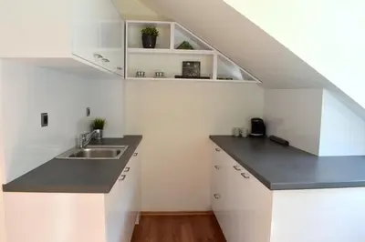a kitchen with white cabinets and a sink at NEW CENTRAL ROOFTOP with private WELLNESS, Sauna & Whirlpool bath in Prague