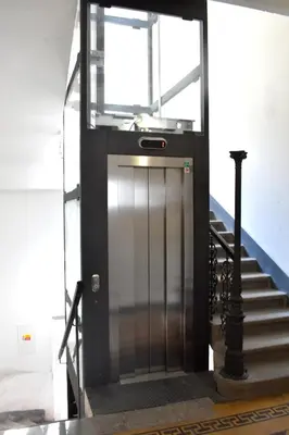 a metal elevator door in a building with stairs at NEW CENTRAL ROOFTOP with private WELLNESS, Sauna & Whirlpool bath in Prague