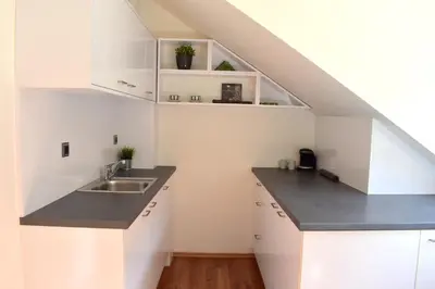 a kitchen with white cabinets and a sink at NEW CENTRAL ROOFTOP with private WELLNESS, Sauna & Whirlpool bath in Prague