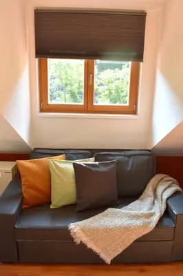 a black leather couch in a room with a window at NEW CENTRAL ROOFTOP with private WELLNESS, Sauna & Whirlpool bath in Prague