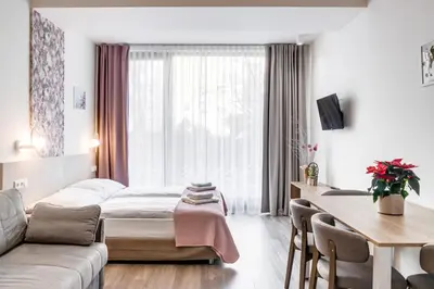 a hotel room with a bed and a table and chairs at Kora Apartments in Prague