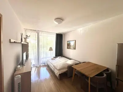 a living room with a bed and a table at Kora Apartments in Prague