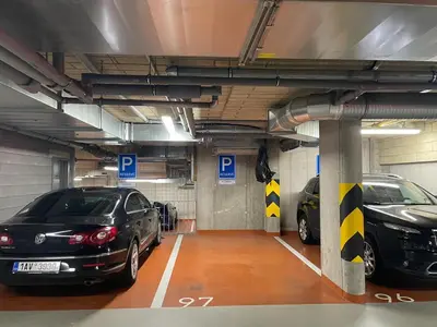 a parking garage with two cars parked in it at Kora Apartments in Prague