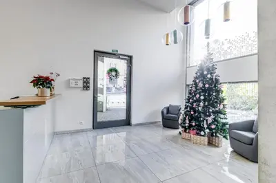 a christmas tree in a living room with a door at Kora Apartments in Prague