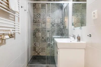 a white bathroom with a sink and a shower at Kora Apartments in Prague