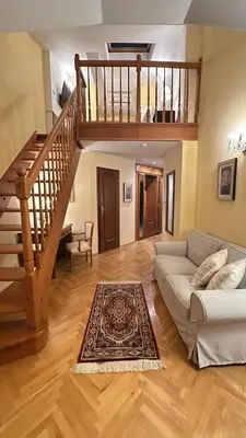 a living room with a couch and a staircase at FLEUR DE LIS HOTEL in Prague