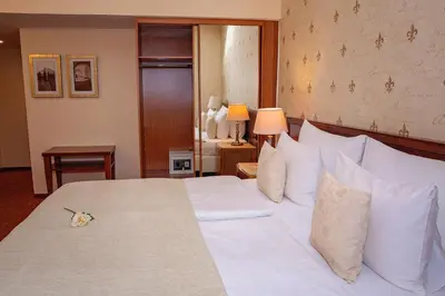 a bedroom with a large bed with white sheets and pillows at FLEUR DE LIS HOTEL in Prague